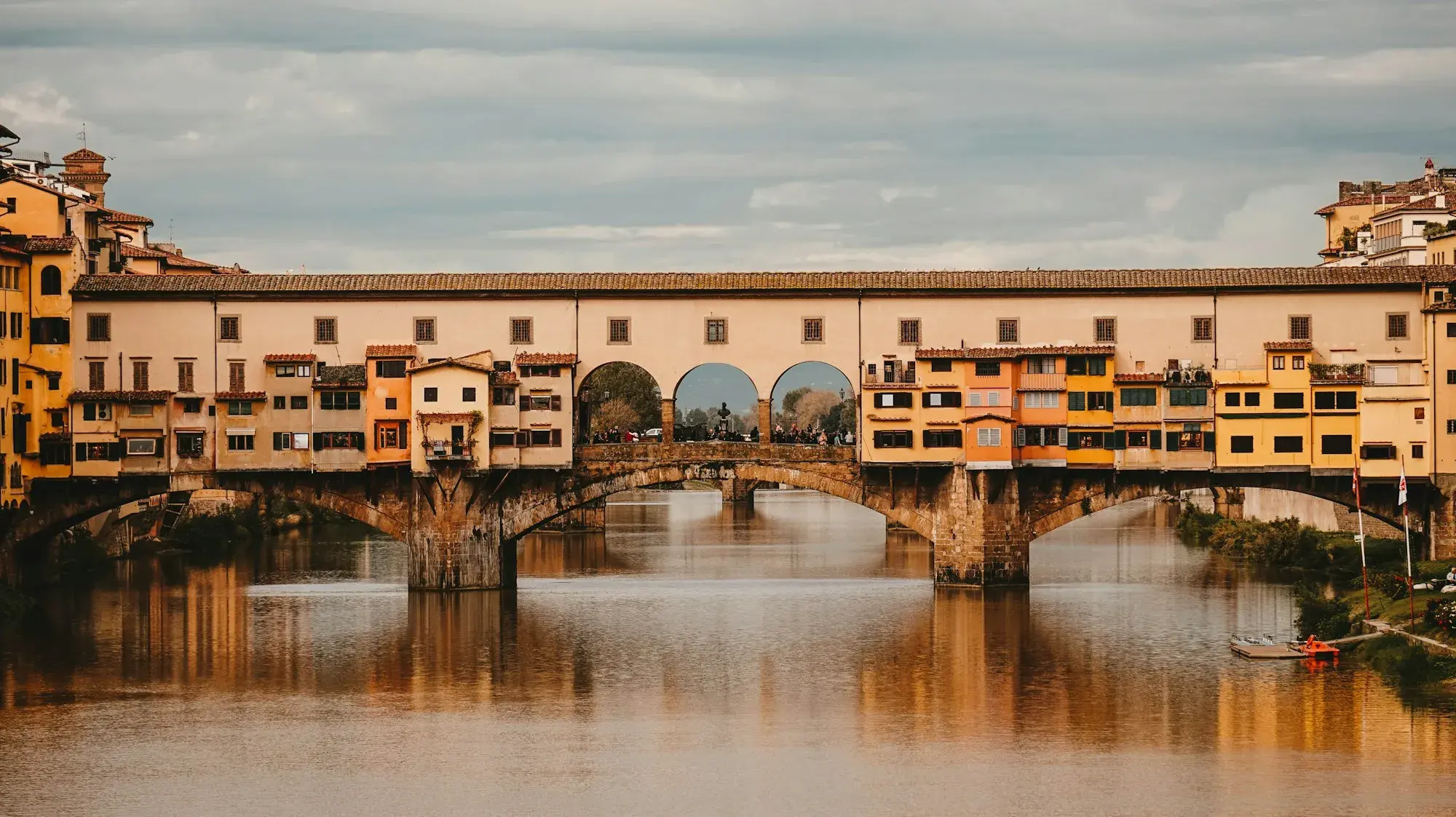 The Ponte Vecchio in Florence, with its shops built along the bridge, reflected in the Arno