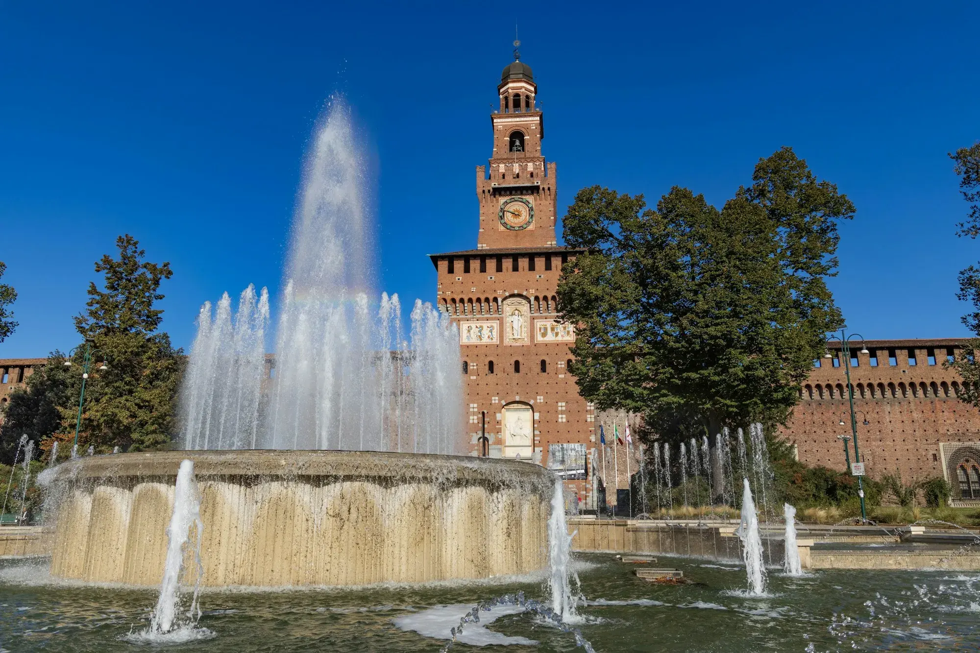 The fountain in front of the Castello Sforzesco in Milan with the castle's tower behind