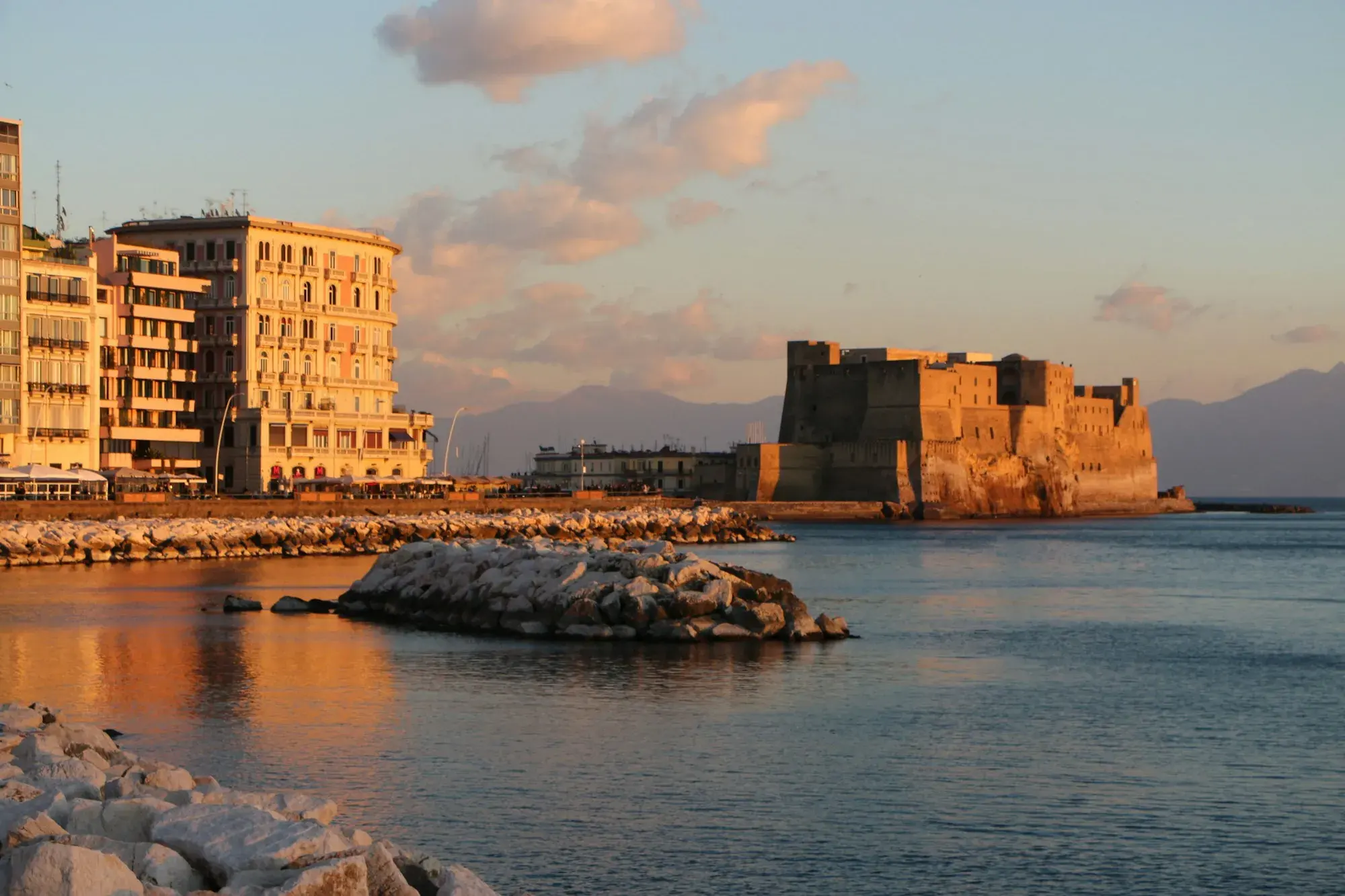 Castel dell'Ovo on the Naples seafront at sunset, seen across the water
