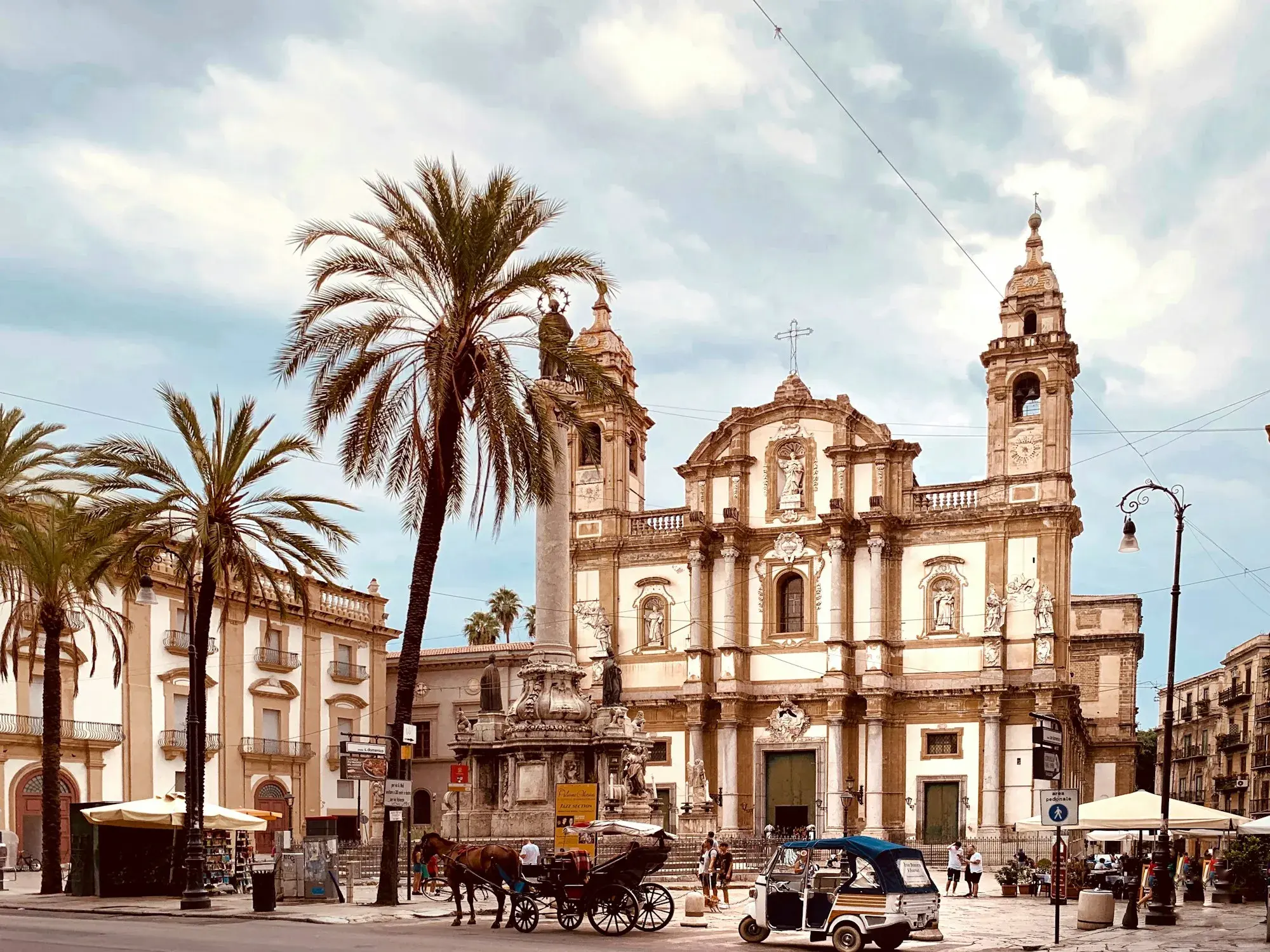 Piazza San Domenico in Palermo, with the Baroque church of San Domenico, a tall column topped by a statue and palm trees