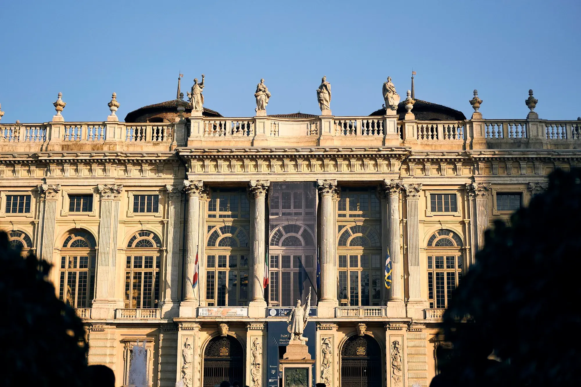 The Baroque stone façade of Palazzo Madama in Piazza Castello, Turin, with statues along the roofline