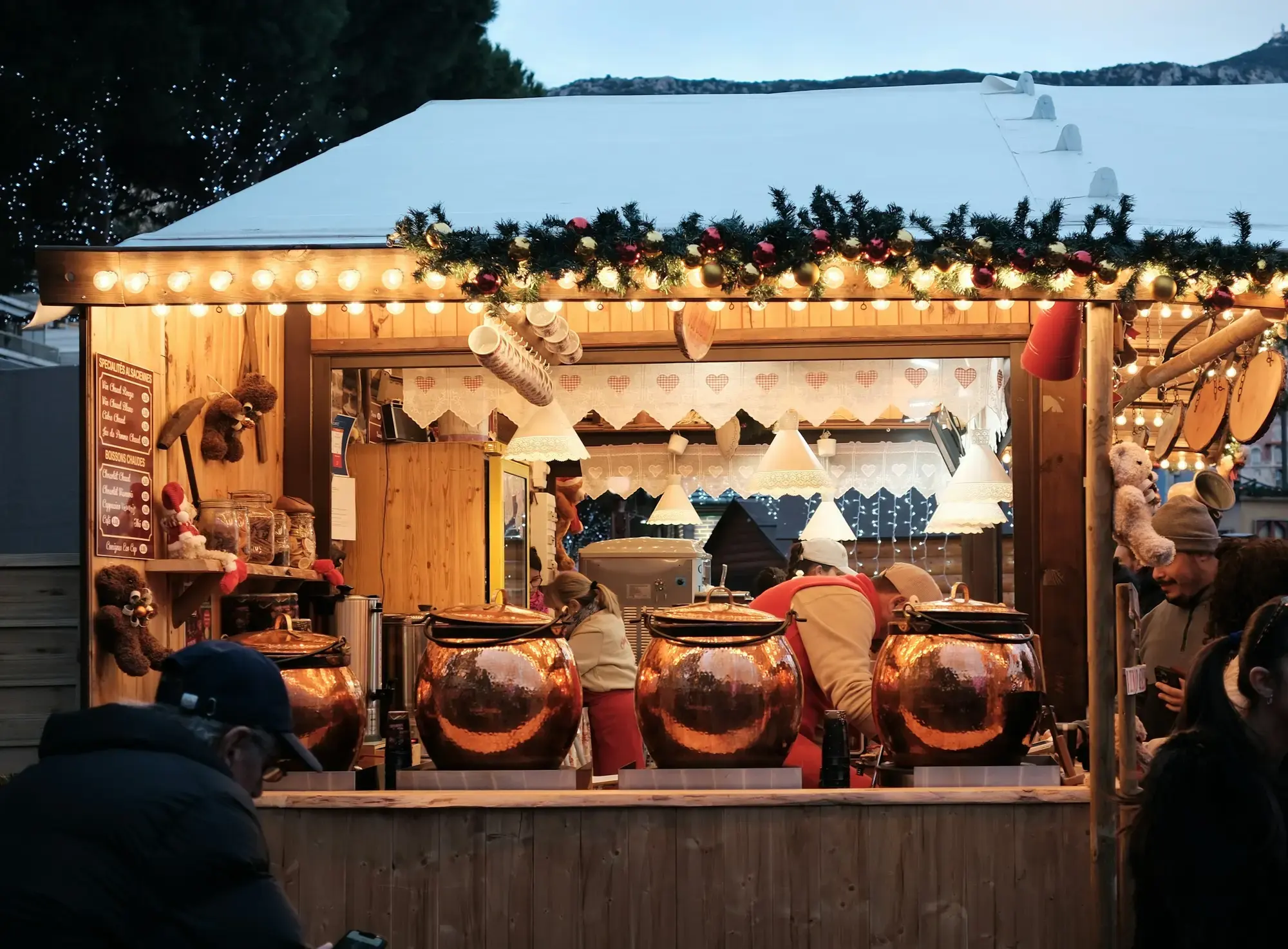 Una casetta del mercatino con luci calde color ambra, struttura in legno e decorazioni natalizie