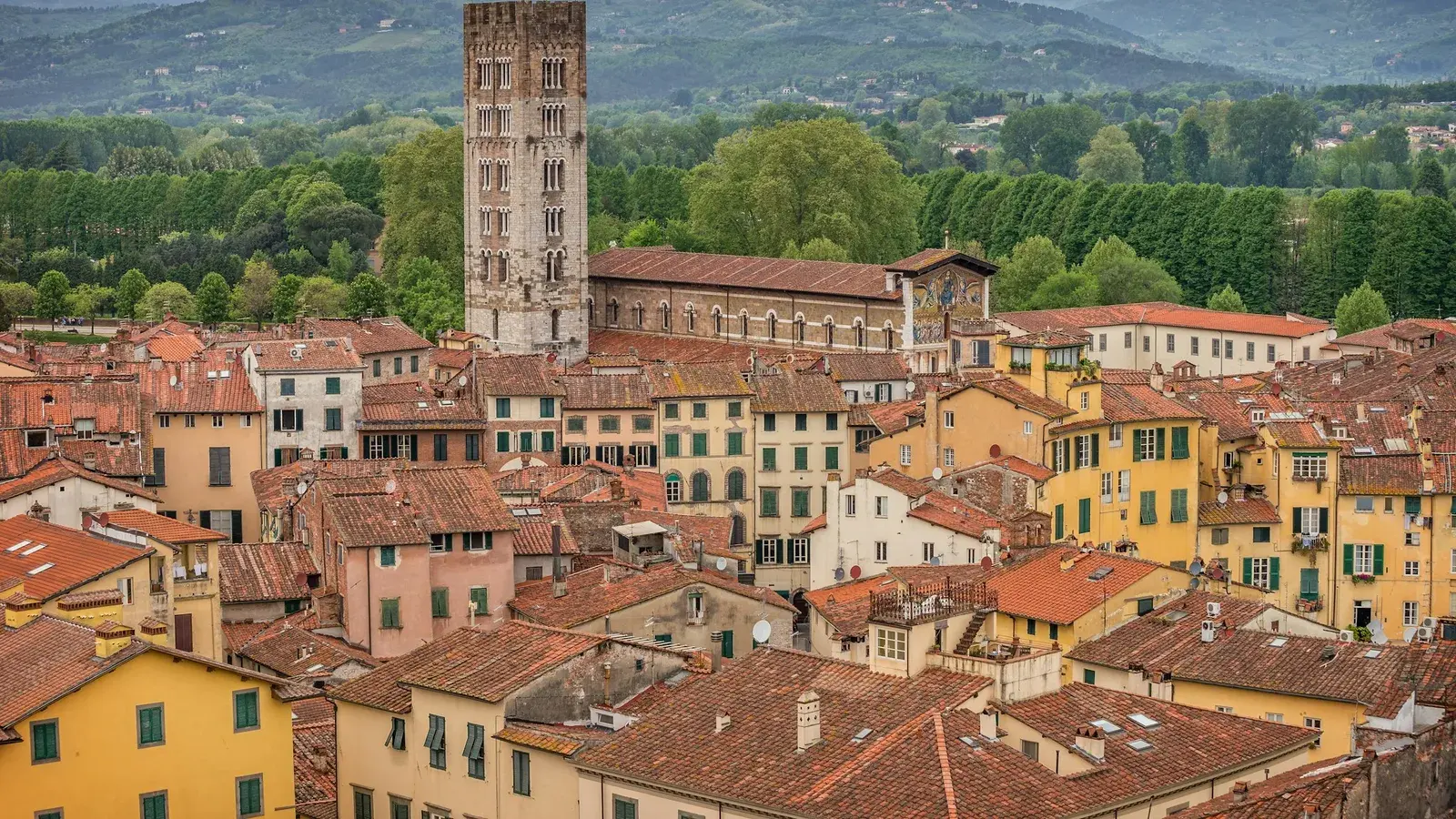 Lucca's historic skyline with its medieval towers and church spires set against the Tuscan hills