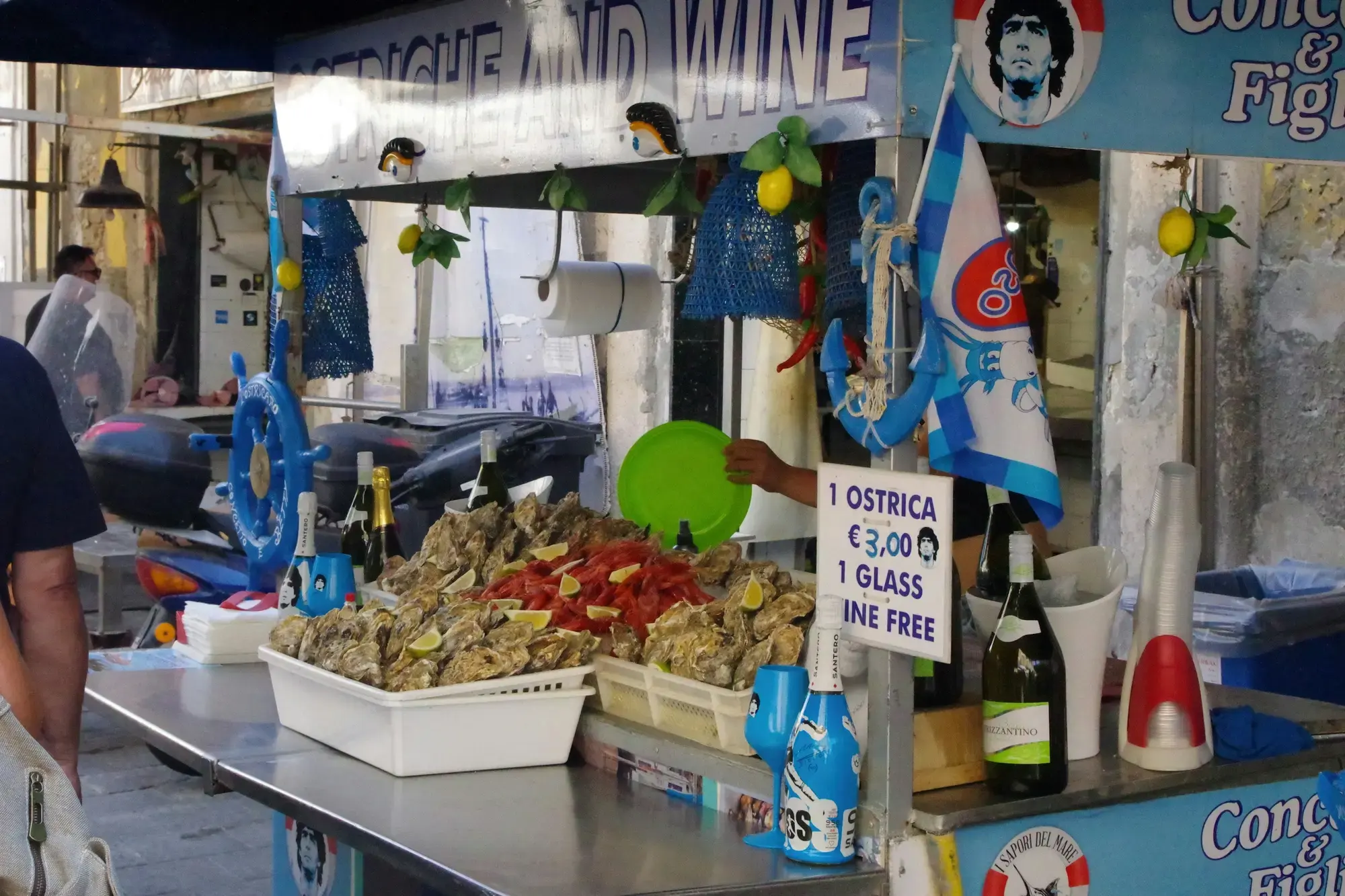 Una persona accanto a uno stand di cibo di strada al mercato