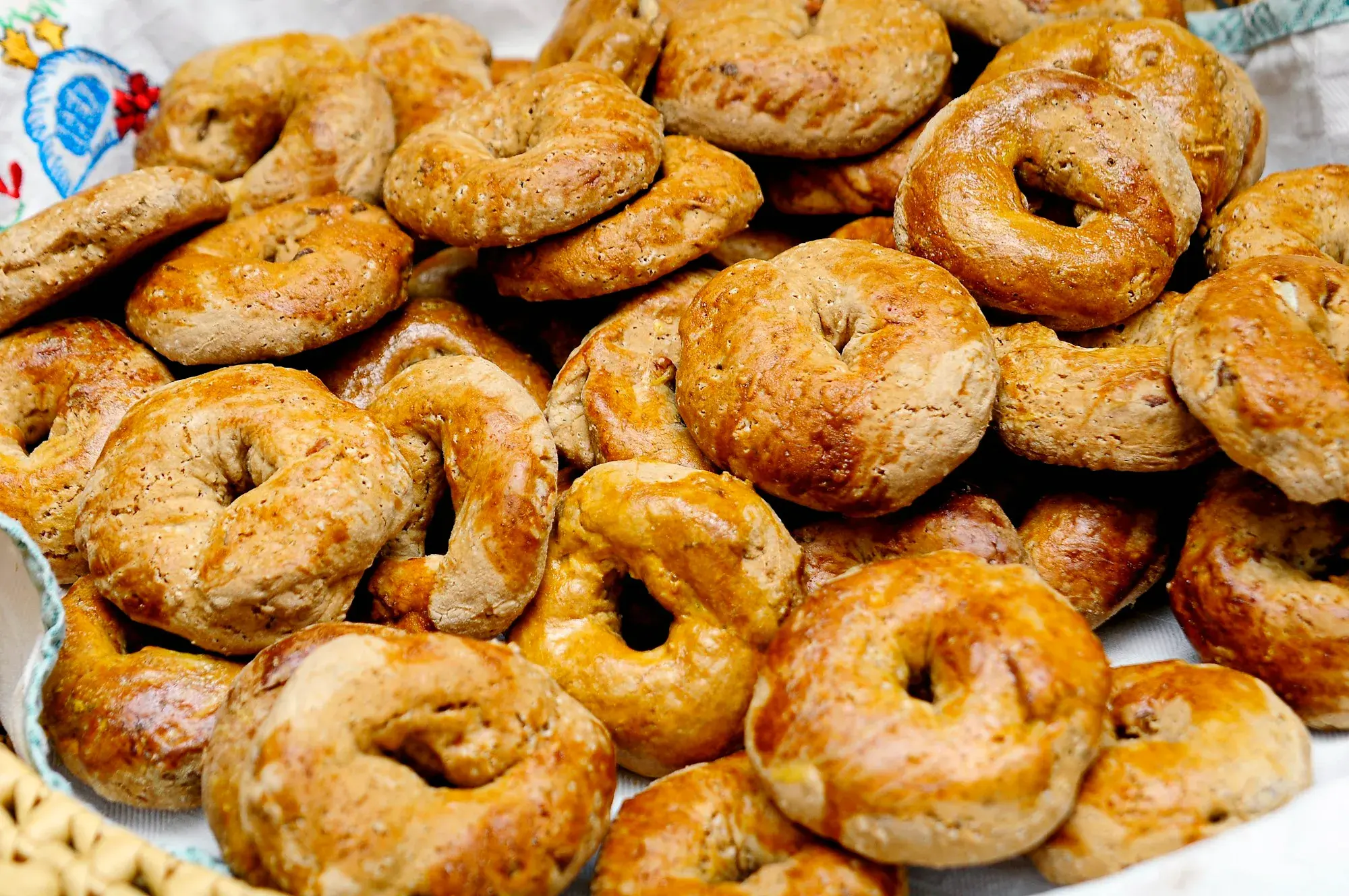 A heap of glazed, ring-shaped Christmas biscuits studded with almonds on a tray