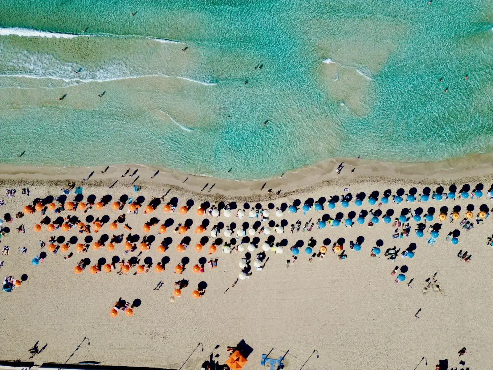 Aerial view of the beach at San Vito Lo Capo in Sicily in summer, with rows of umbrellas and turquoise water