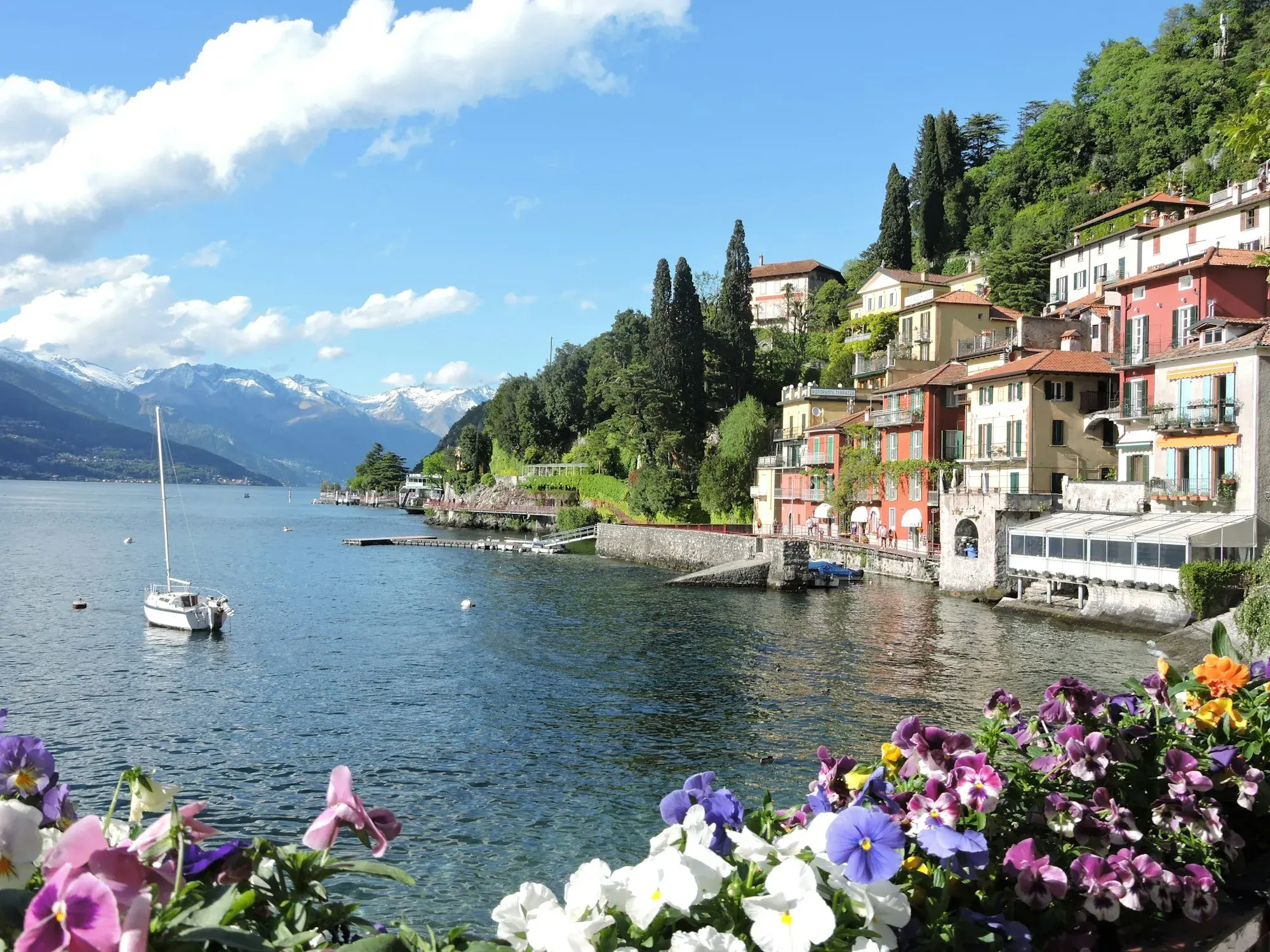 The colourful houses of Varenna beside Lake Como, with boats and mountains in the background