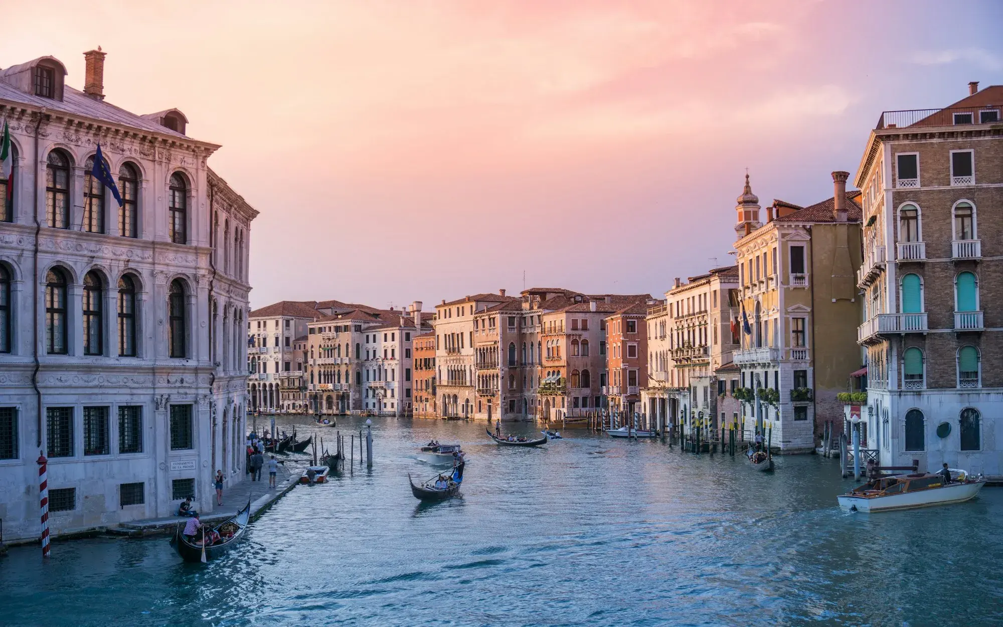 Gondole ormeggiate sul Canal Grande vicino al ponte di Rialto, a Venezia, al tramonto