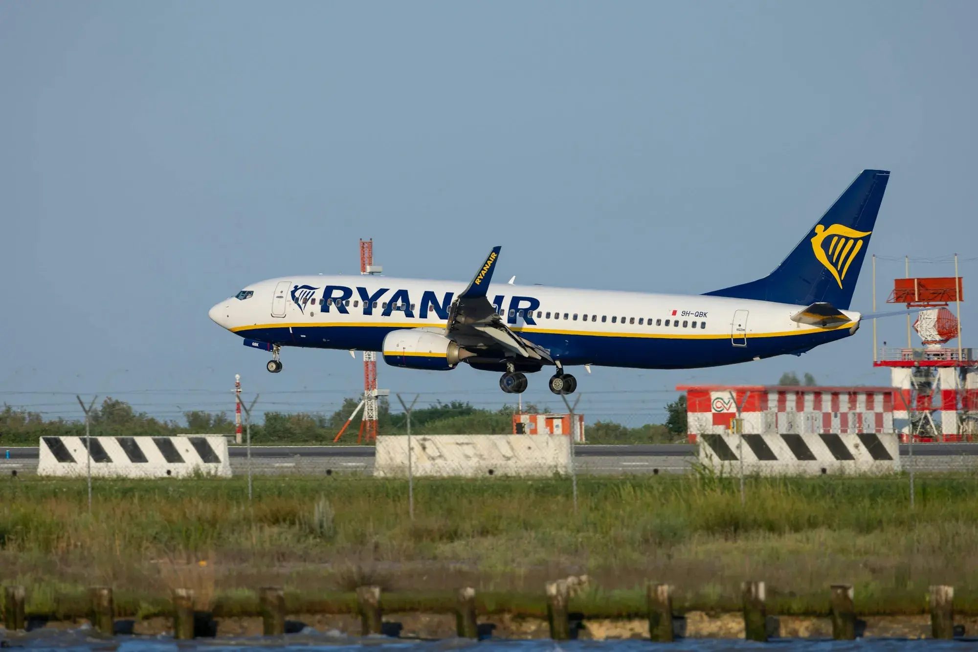 A passenger jet landing on the runway at Venice Marco Polo airport, with its landing gear down