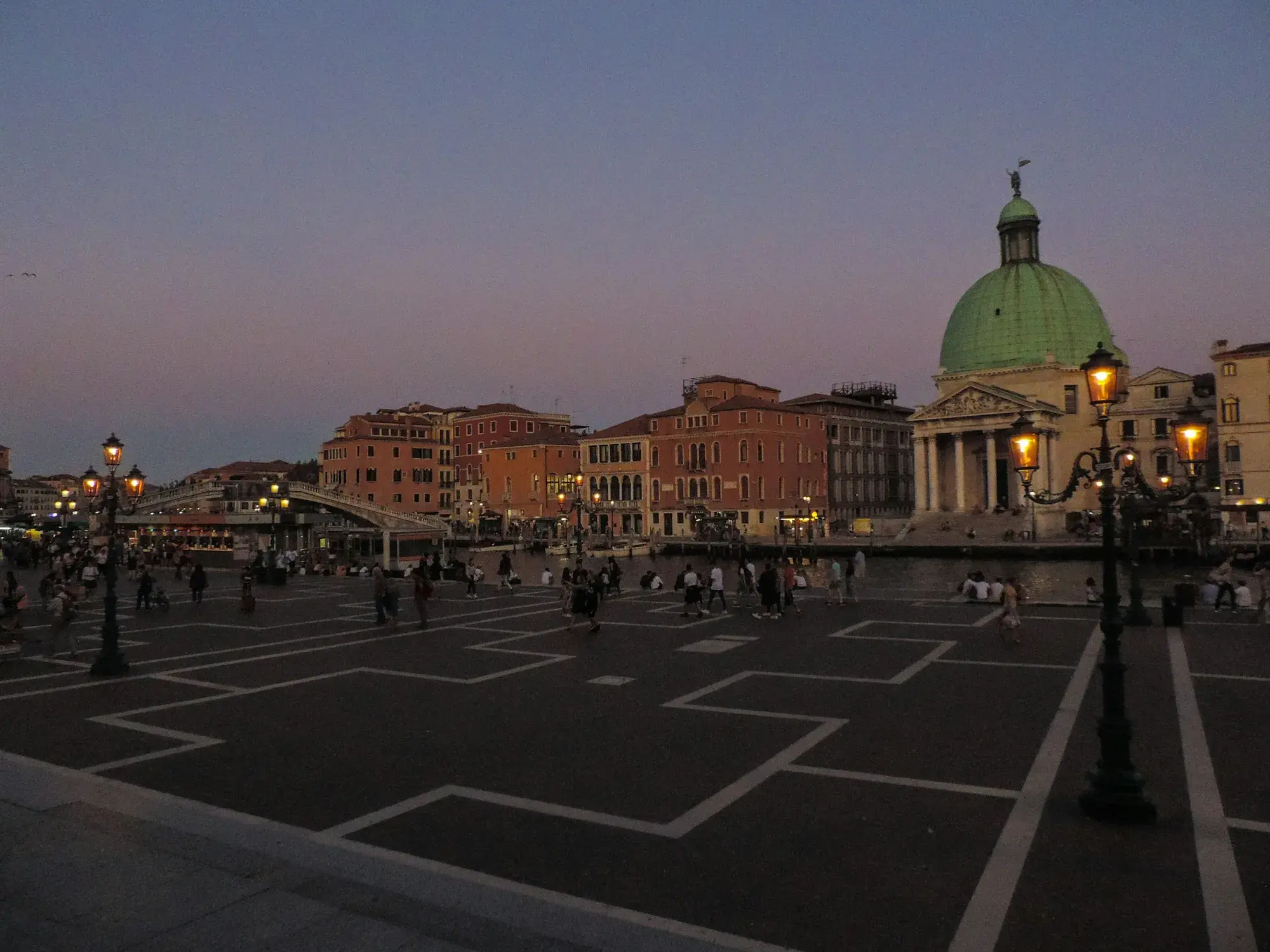 Evening at Piazzale Roma in Venice, with street lamps and the green dome of San Simeone Piccolo in the distance