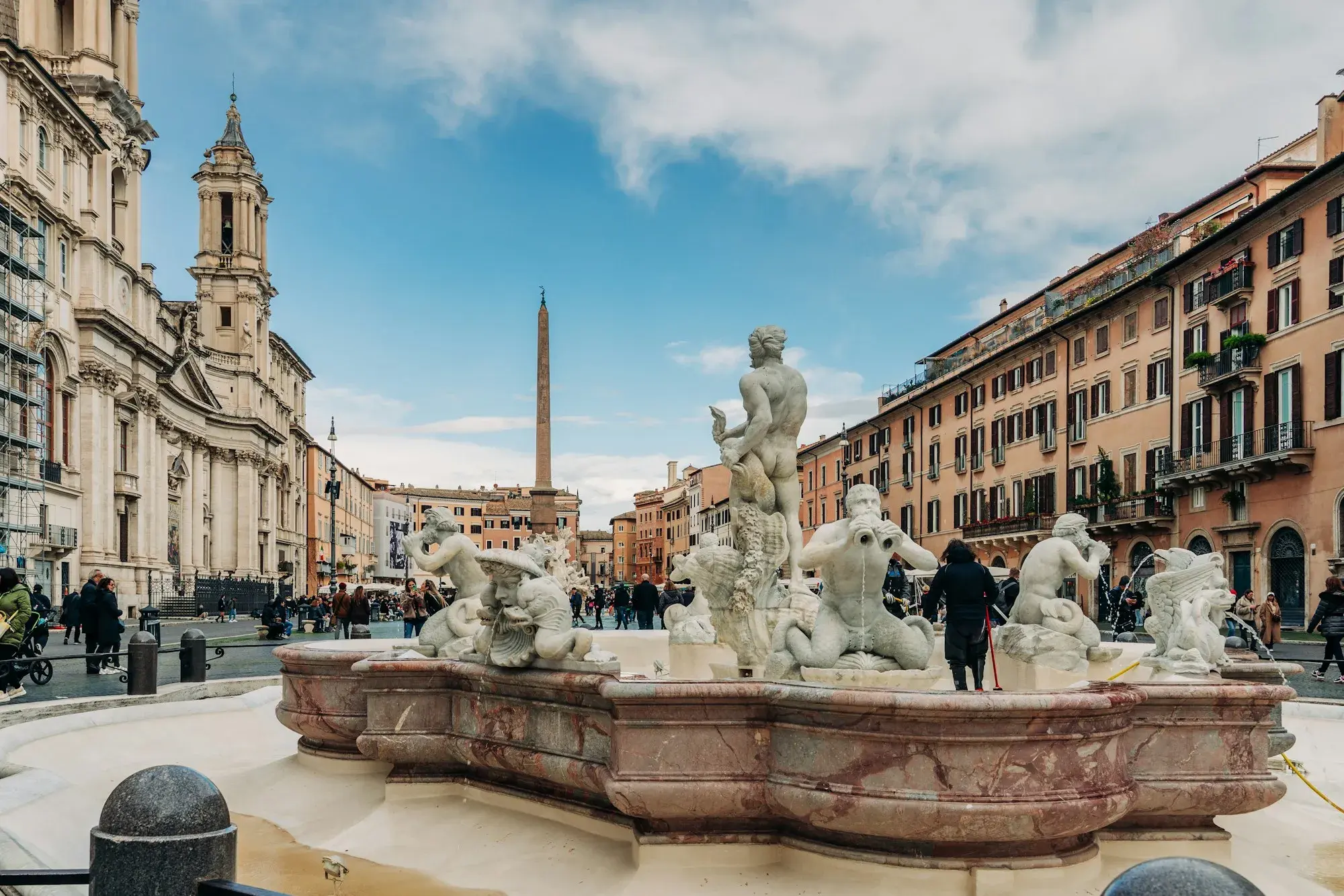 Piazza Navona in Rome with a Baroque fountain in the foreground, the church of Sant'Agnese and ochre palaces around the long square