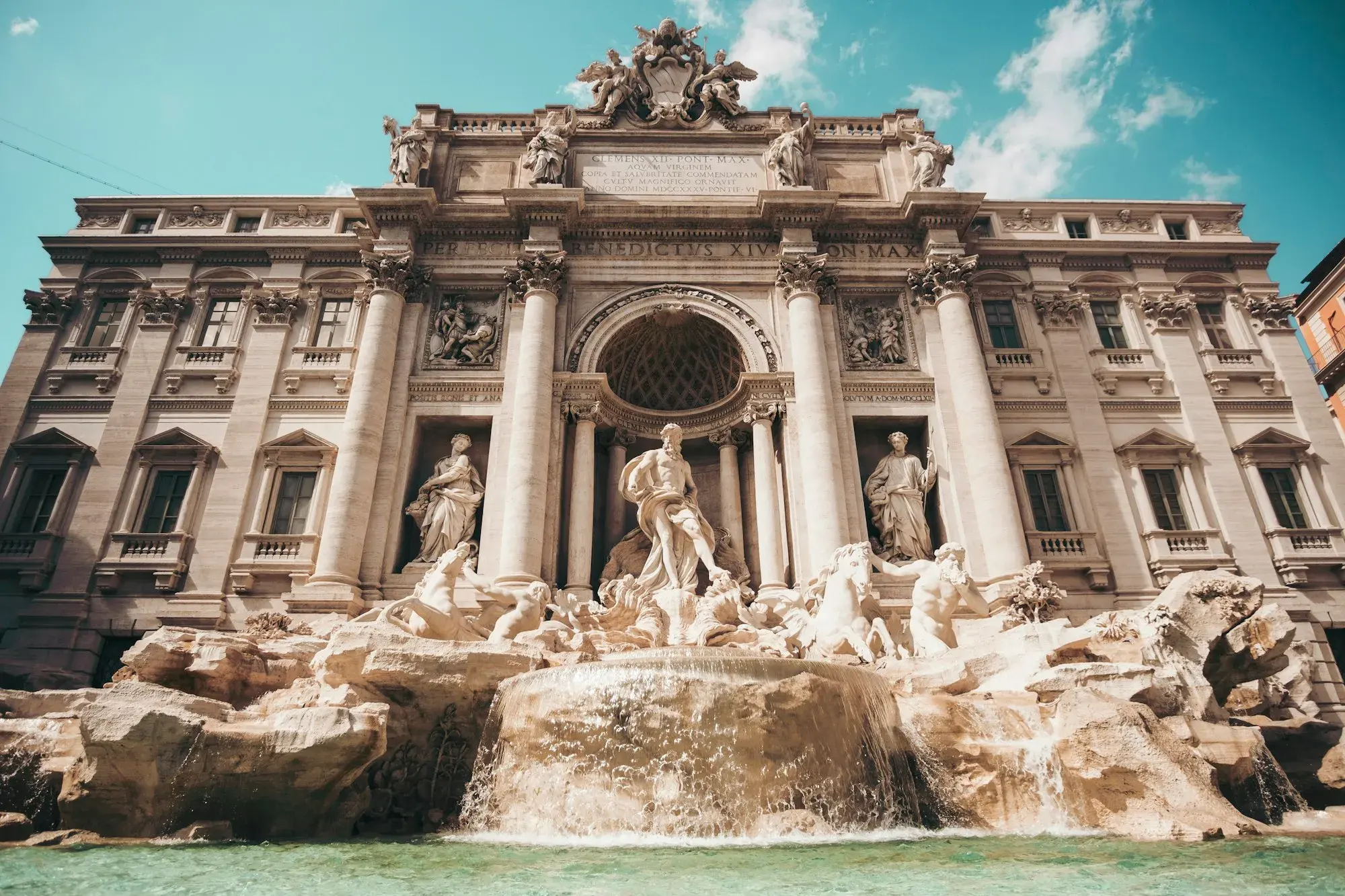 The Trevi Fountain in Rome, with marble statues, cascading water and the palace façade behind it