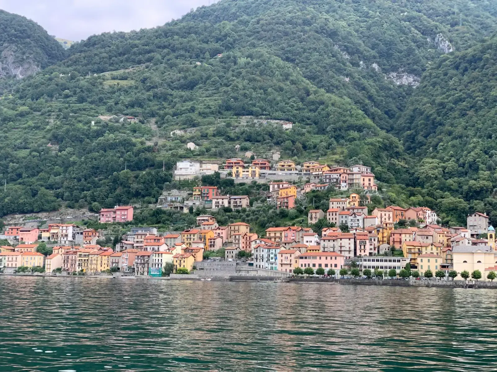 The houses of Menaggio along the shore of Lake Como below wooded mountains