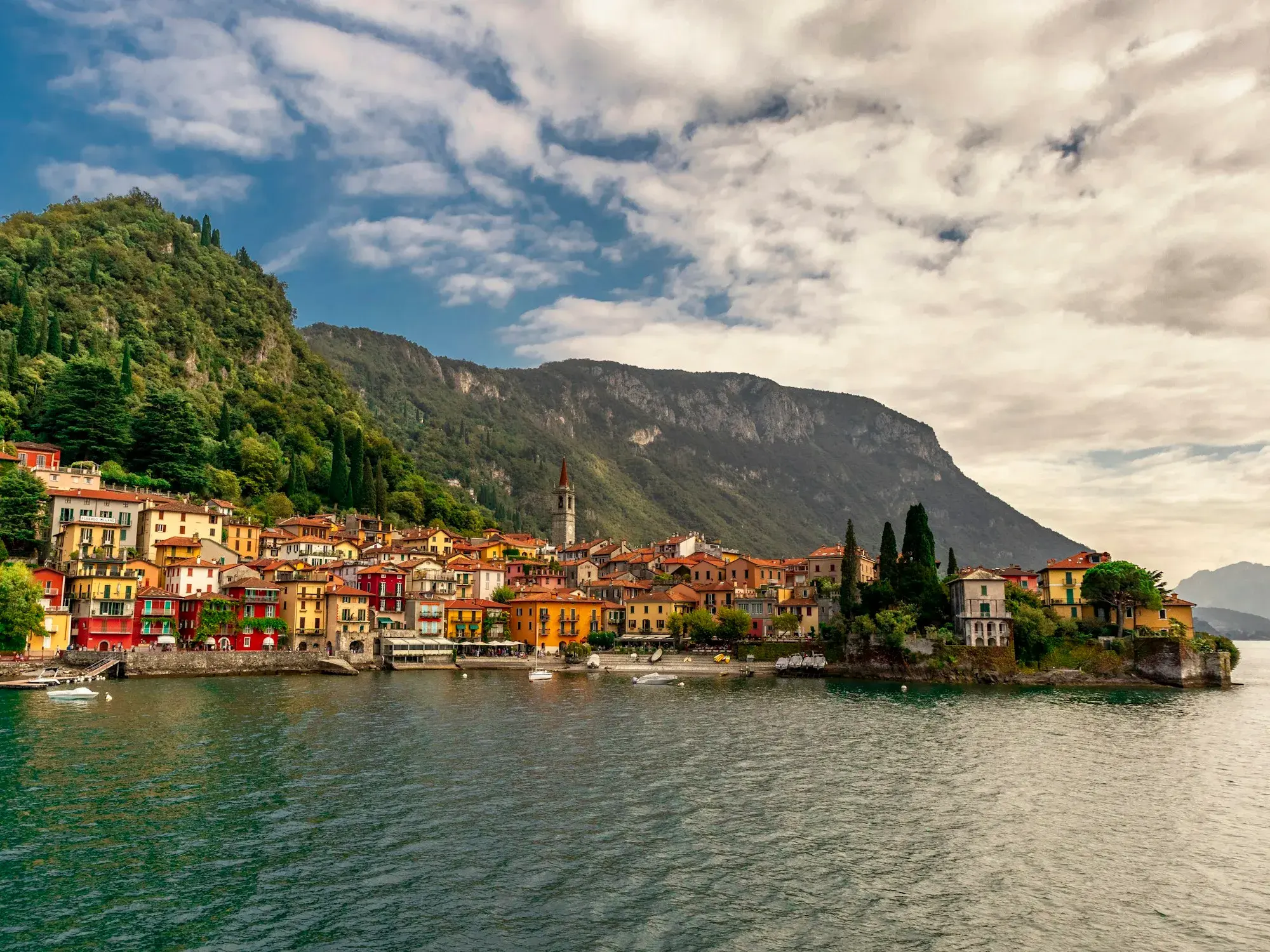 The colourful houses of Varenna on the shore of Lake Como under a cloudy sky