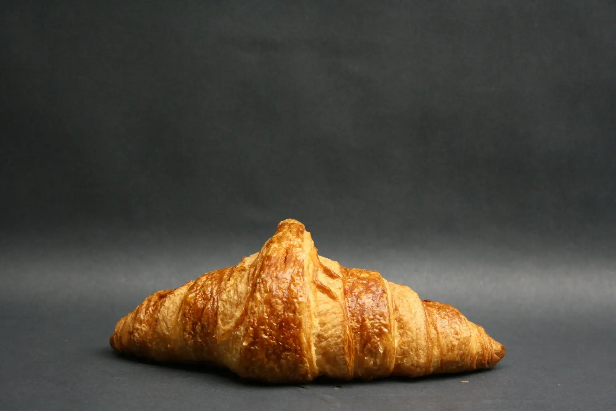 A croissant-style pastry resting on a café table