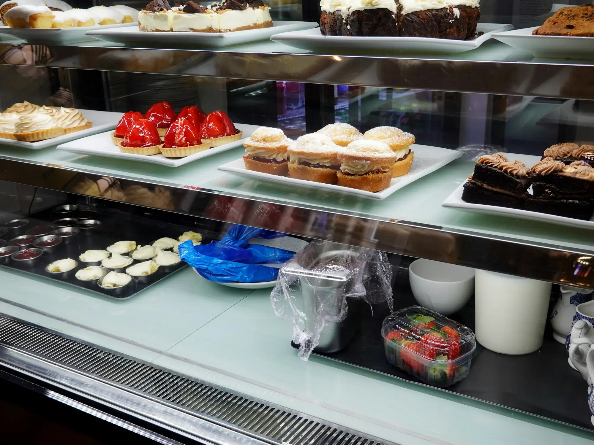 An assortment of pastries and desserts arranged in a café display case