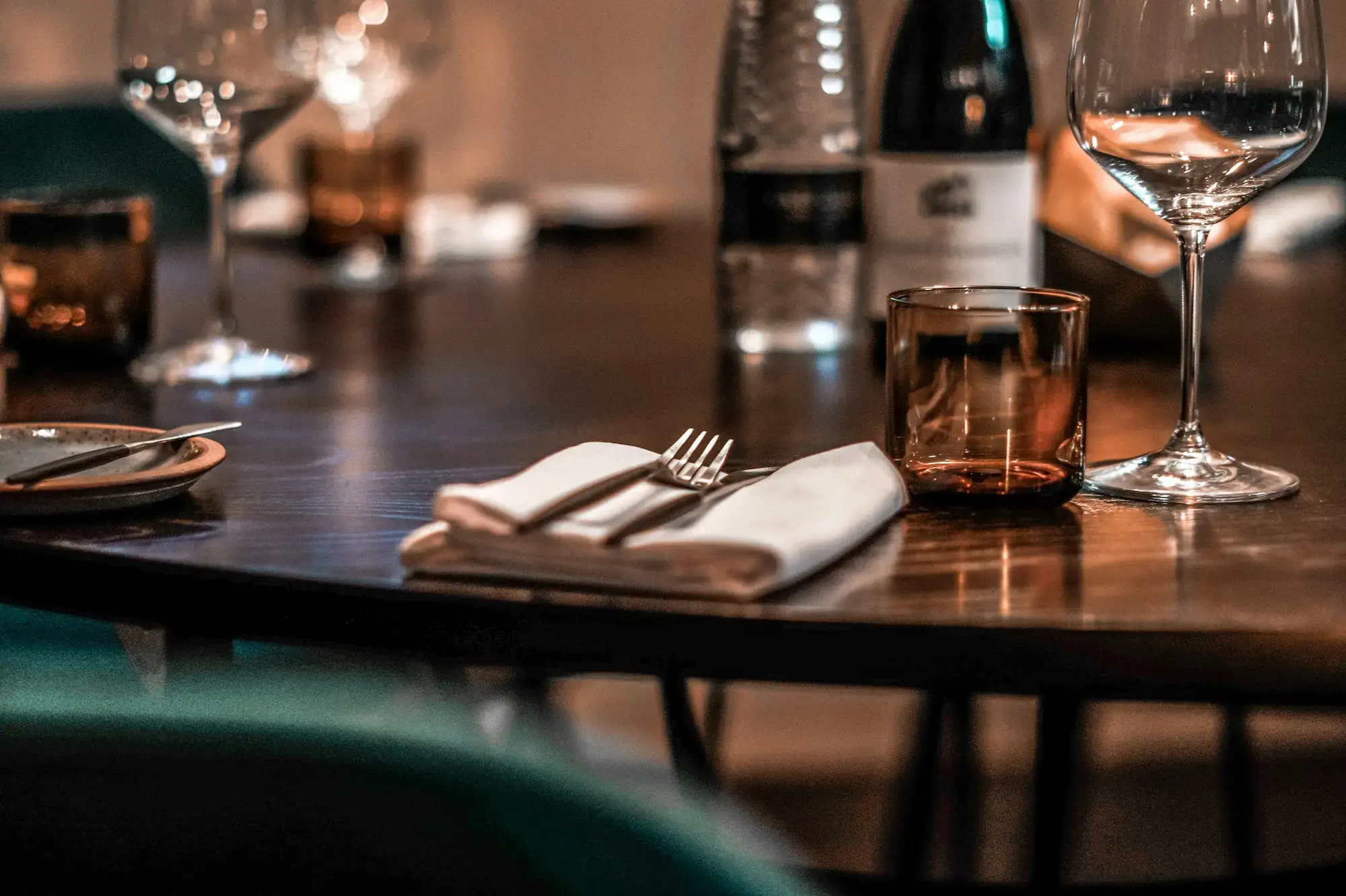 A white ceramic plate with a silver fork and knife set alongside on a white tablecloth, a typical Italian restaurant place setting
