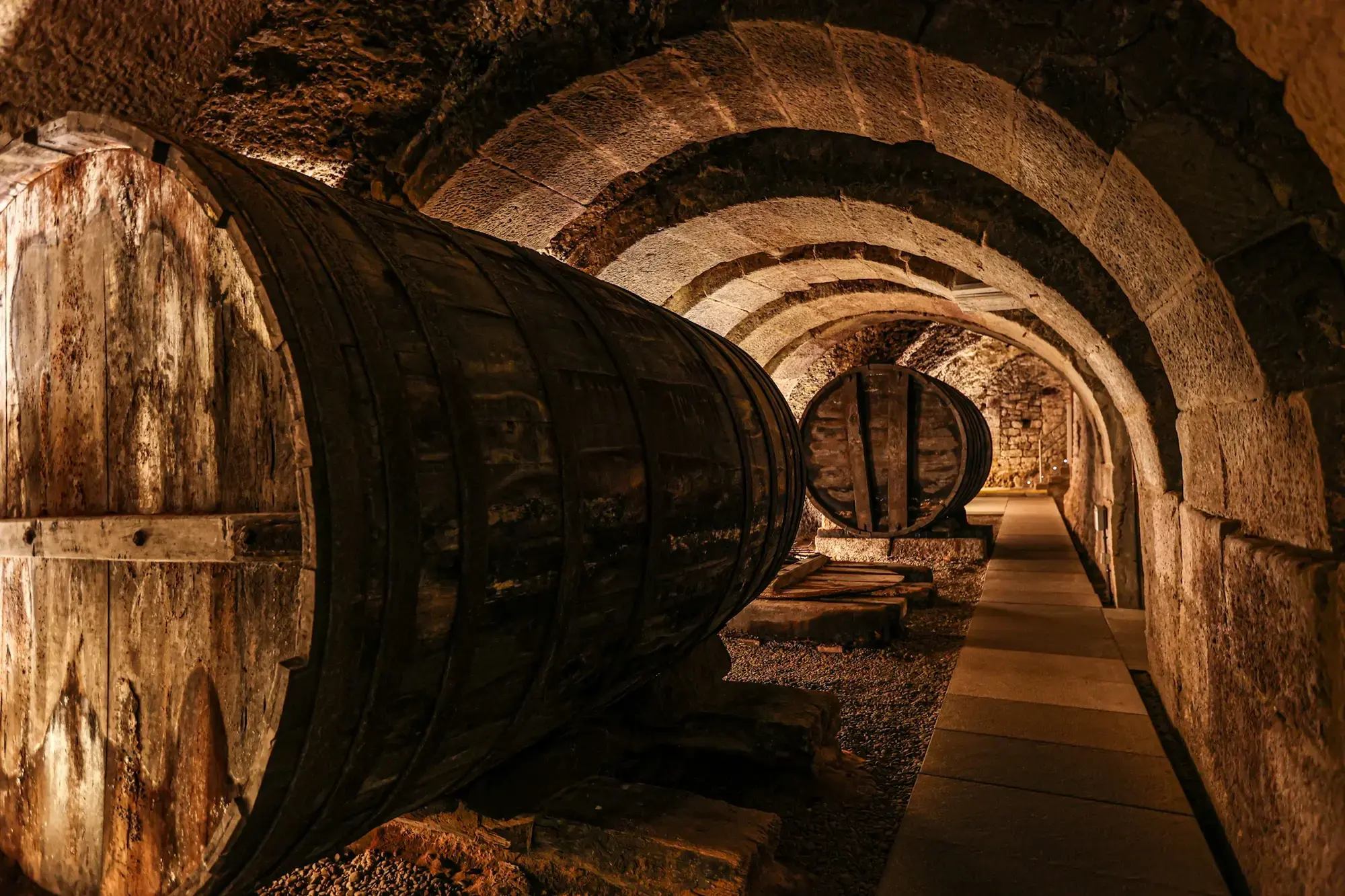 A long stone-vaulted underground corridor or cellar used for aging and storing food or drink