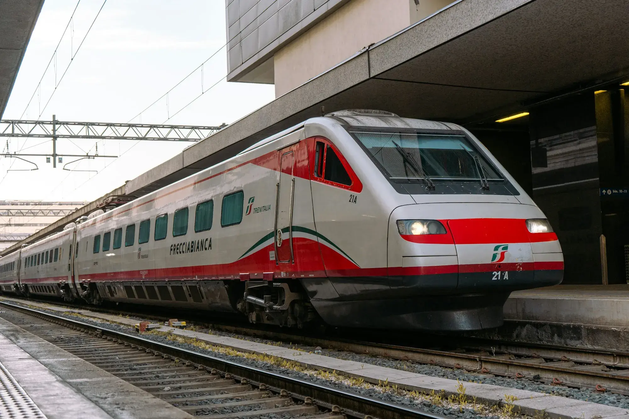 A red, white and grey Trenitalia Frecciabianca train at a platform at Roma Termini